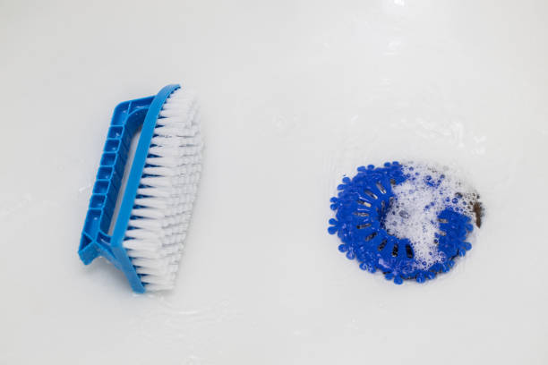 istock cleaning a white bathtub with a brush. 1828534859