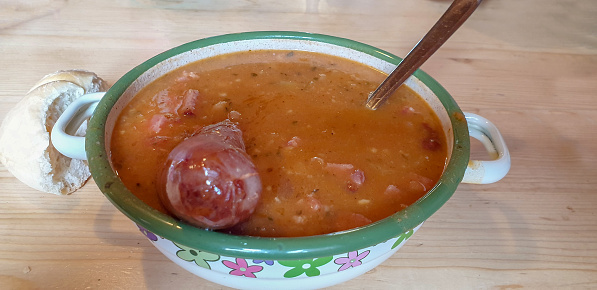 Pot of traditional bean soup with half of sausage