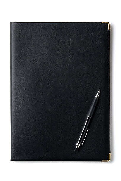 isolierte schuss von schwarz notizbuch mit stift auf weißem hintergrund - pen color image black book stock-fotos und bilder