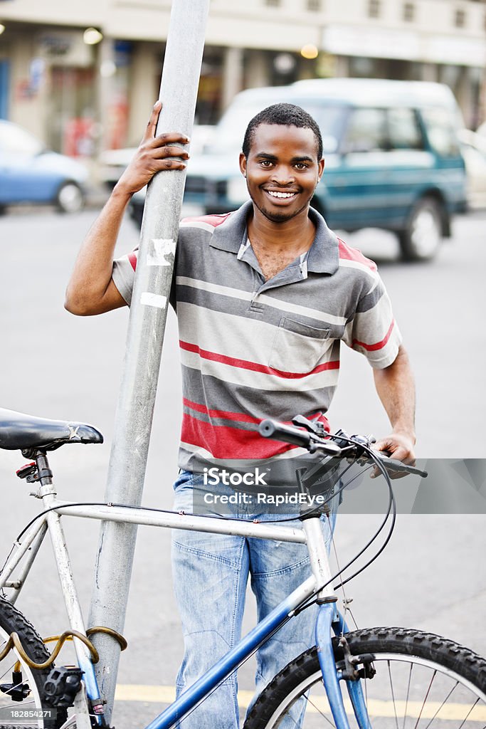 Sonriente joven hombre africano con bicicleta en la calle - Foto de stock de 20 a 29 años libre de derechos