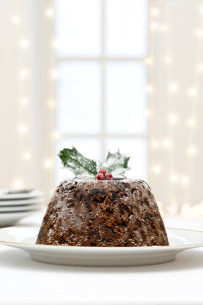 Christmas Pudding Christmas pudding with window and fairy lights in background. christmas pudding stock pictures, royalty-free photos & images