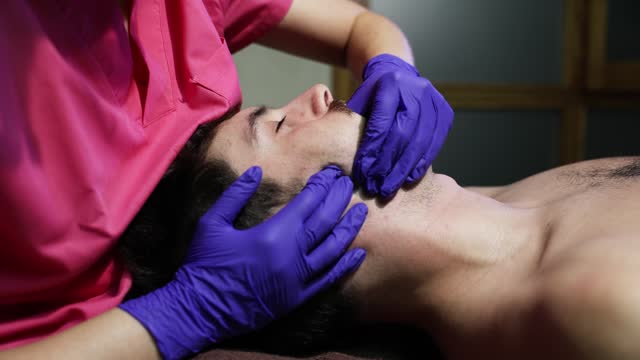 Physiotherapist applying intraoral massage therapy on patient.