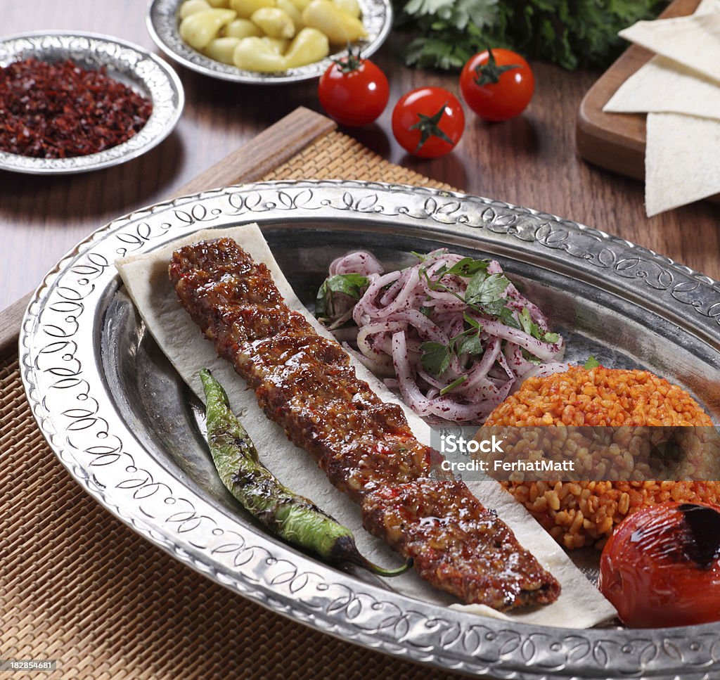 Traditional Turkish Adana Kebab Adana Kebab (Urfa Kebab) in traditional plate server with tomato and pepper. Shoot in studio.Food and Drink. Kebab Stock Photo