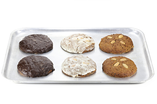 Original Nuremberg Elisen type Lebkuchen (gingerbread) on a baking plate isolated on white background. Nuremberg is a city in Germany and well-known for its gingerbread skilled crafts and trades.