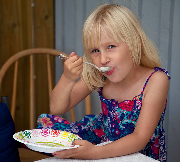 istock Blond girl eating and smiling. 182855405