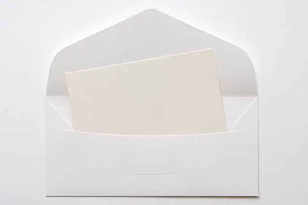 Rear view of opened  white envelope with a blank card  isolated on white background.