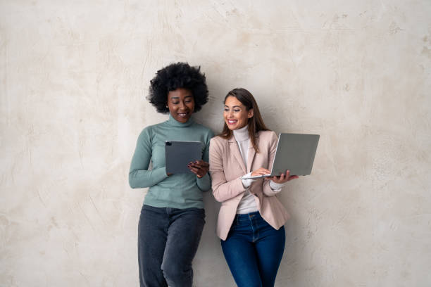 istock Two diverse young women using digital tablet and laptop 1828554708