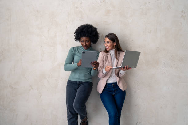 istock Two successful female entrepreneurs with digital tablet and laptop. Studio photo 1828555230