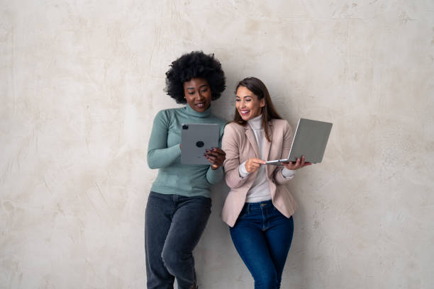 istock Two female entrepreneurs standing against studio background 1828555231
