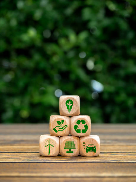 istock Eco friendly, green renewable energy icons on wooden cube block stack pyramid shape on green leaves background, vertical style. Environmental sustainability, Net zero carbon dioxide reduction concept. 1828556278