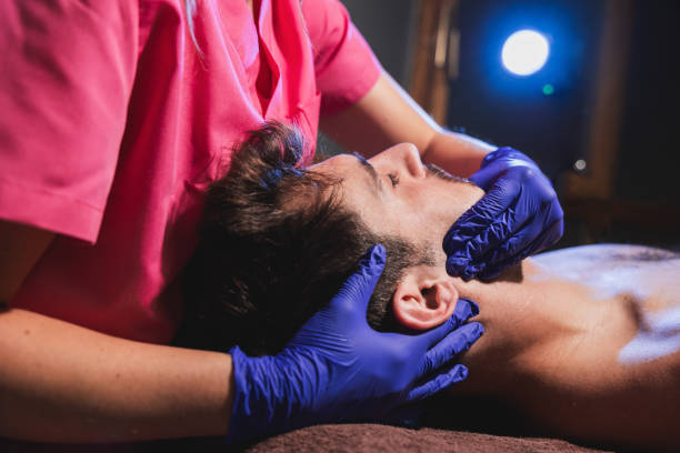 Physiotherapist applying intraoral massage therapy on patient. stock photo