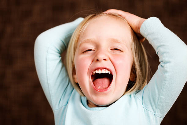 istock Happy 3 year old girl laughs, hands on head 182856065