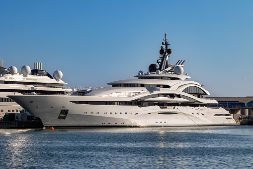 Large modern super-yacht moored in Tarragona harbor on sunny summer day with copy space