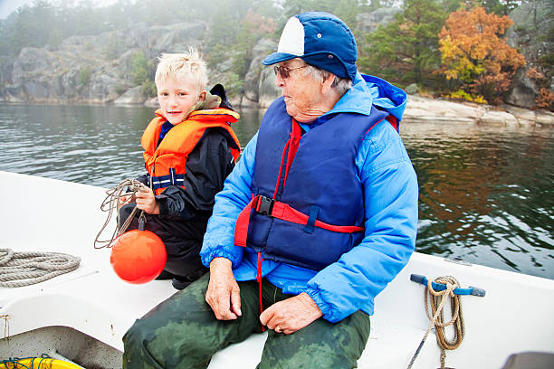 garçon et de grand-mère sur le bateau - sweden fishing child little boys photos et images de collection