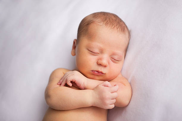 istock Newborn Baby Sleeping Peacefully with Arms Crossed 182857322