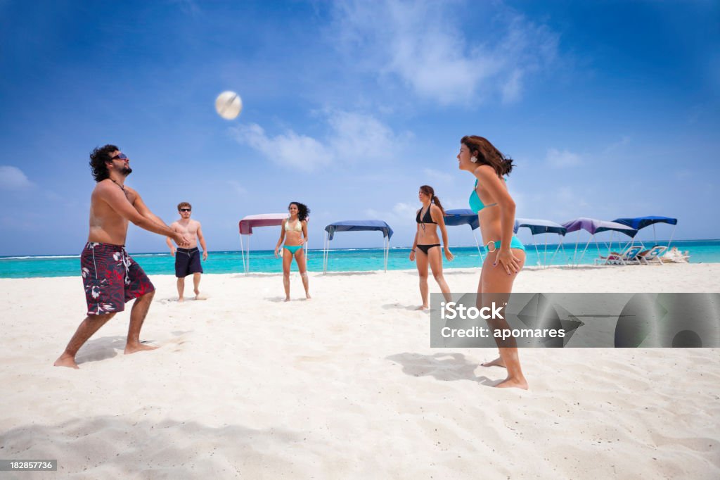 Giovani giocare Voleyball su una spiaggia - Foto stock royalty-free di Amicizia