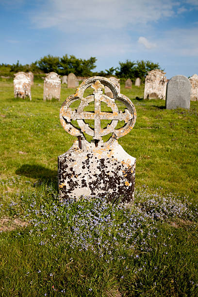 напоминают разваливающиеся надгробная с дикими цветами - celtic cross cross shape blue vertical стоковые фото и изображения