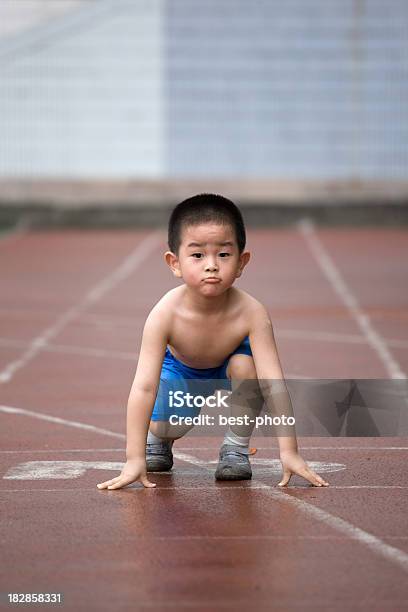 Ragazzo Sulla Pista Sportiva - Fotografie stock e altre immagini di Accovacciarsi - Accovacciarsi, Ambientazione esterna, Asia orientale