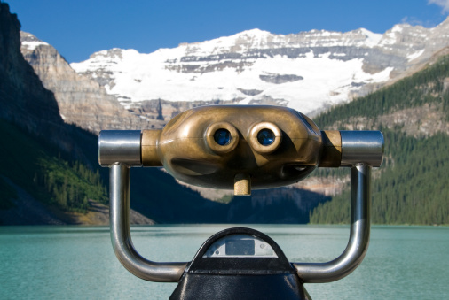 Old fashioned coin operated binoculars pointed at Lake Louise.