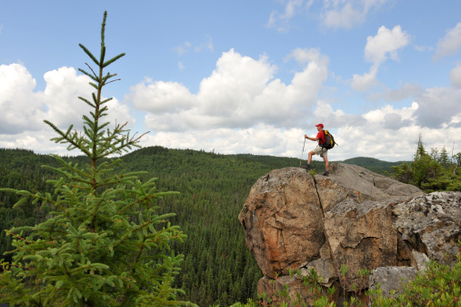 Man hiking on top of a high cliff.