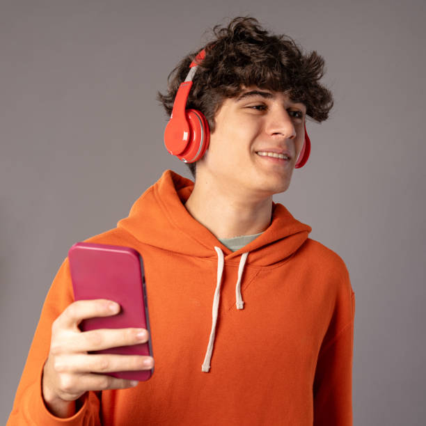 istock Smiling Young Man Enjoying Music on Phone 1828586529