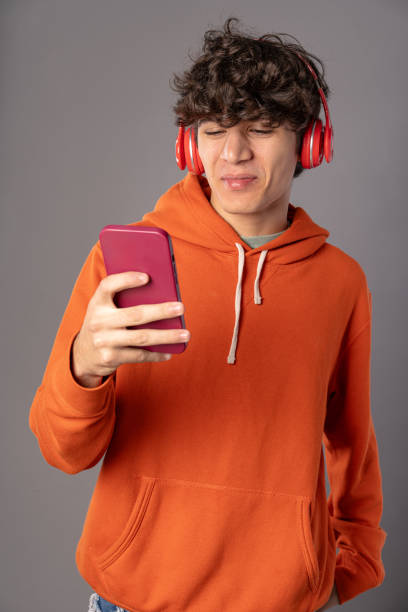 istock Disgusted Young Man with Smartphone and Headphones 1828586537