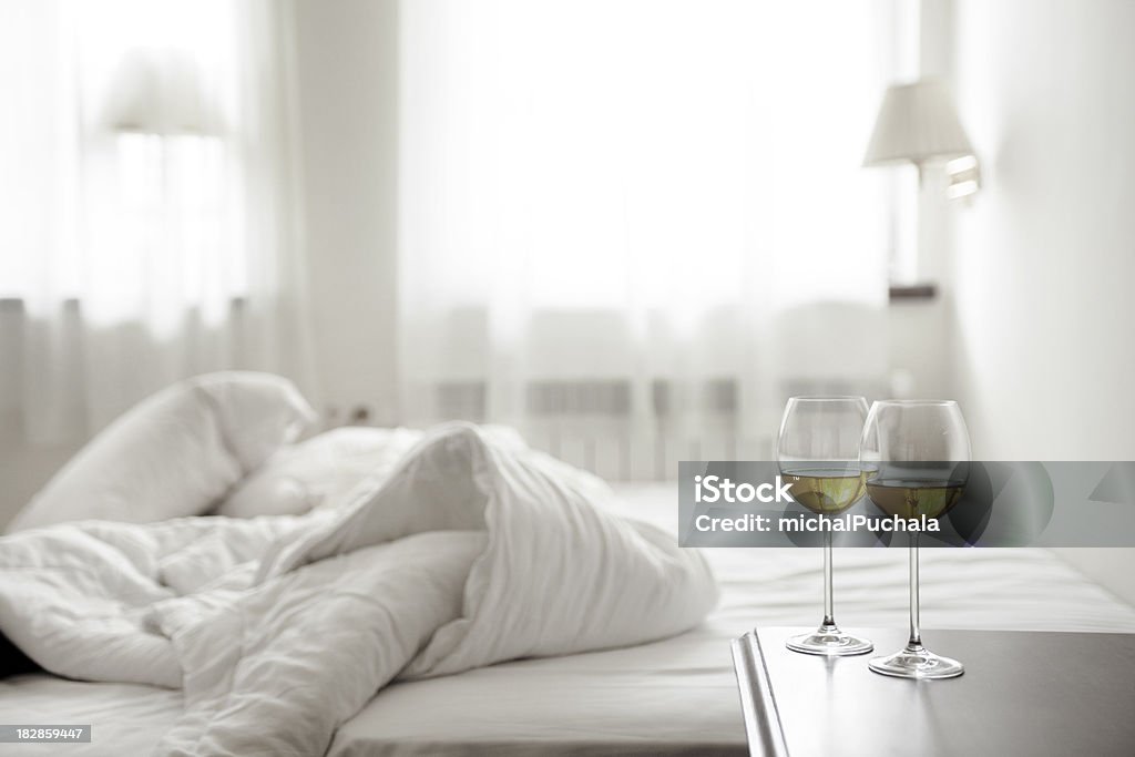 Due wineglasses e sgualcito letto - Foto stock royalty-free di Alchol