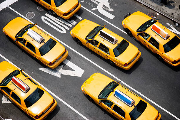 Fleet of Yellow New York City Taxi Cabs from Above Fleet of yellow taxi cabs make their way down the street of Broadway in New York City in view from above taxi photos stock pictures, royalty-free photos & images