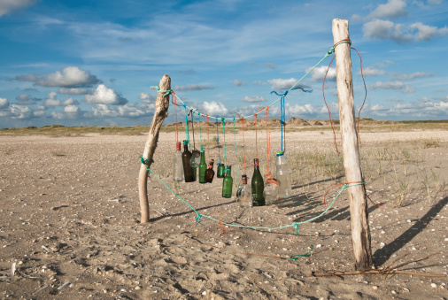 Wind chime of old bottles on a beach