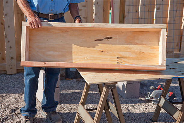 Building A Garden Box Series - Finished Product A senior man displaying a Redwood raised bed garden box that he just finished building. sawhorse stock pictures, royalty-free photos & images