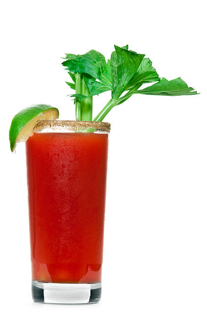 Caesar Cocktail "A caesar cocktail with seasoned rim, slice of lime, and celery on white." bloody mary stock pictures, royalty-free photos & images