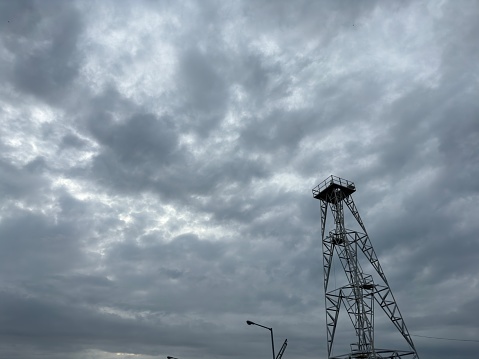 An image of modern beacon tower behind the cloudy sky