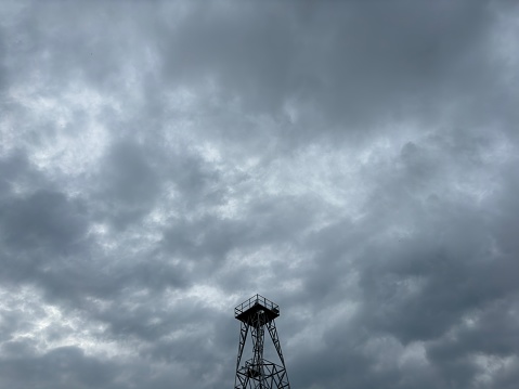 An image of modern beacon tower behind the cloudy sky