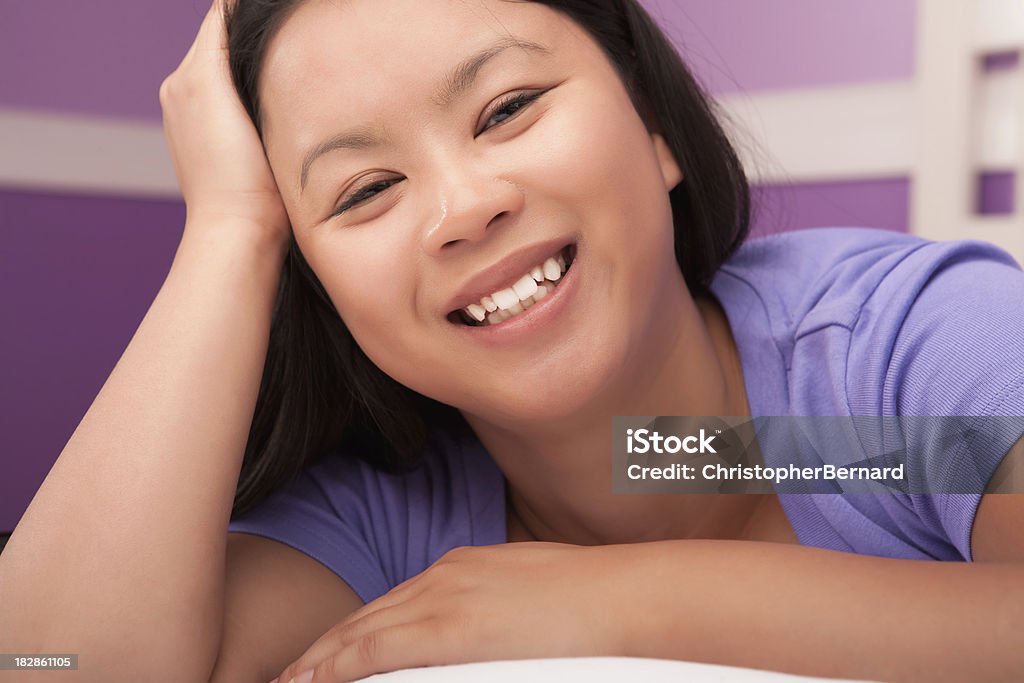 Smiling young asian female laying on bed 20-24 Years Stock Photo