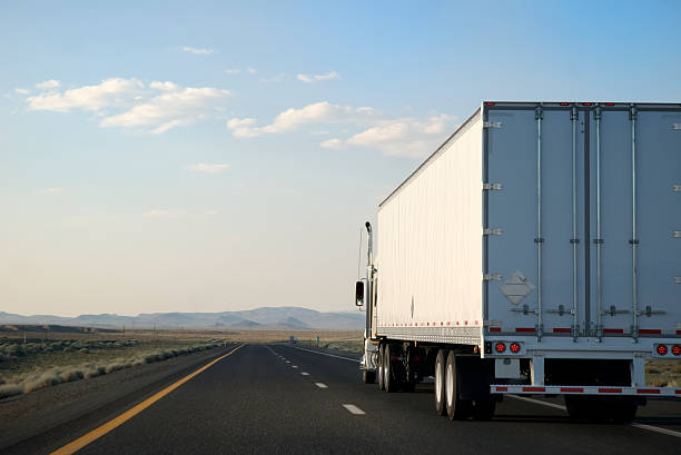 Transporting White Trailer Truck Driving on the Open Road Highway