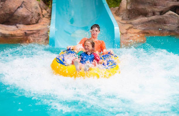 kinder auf der wasserrutsche. familie im aqua-themenpark. - amusement park family water slide child stock-fotos und bilder