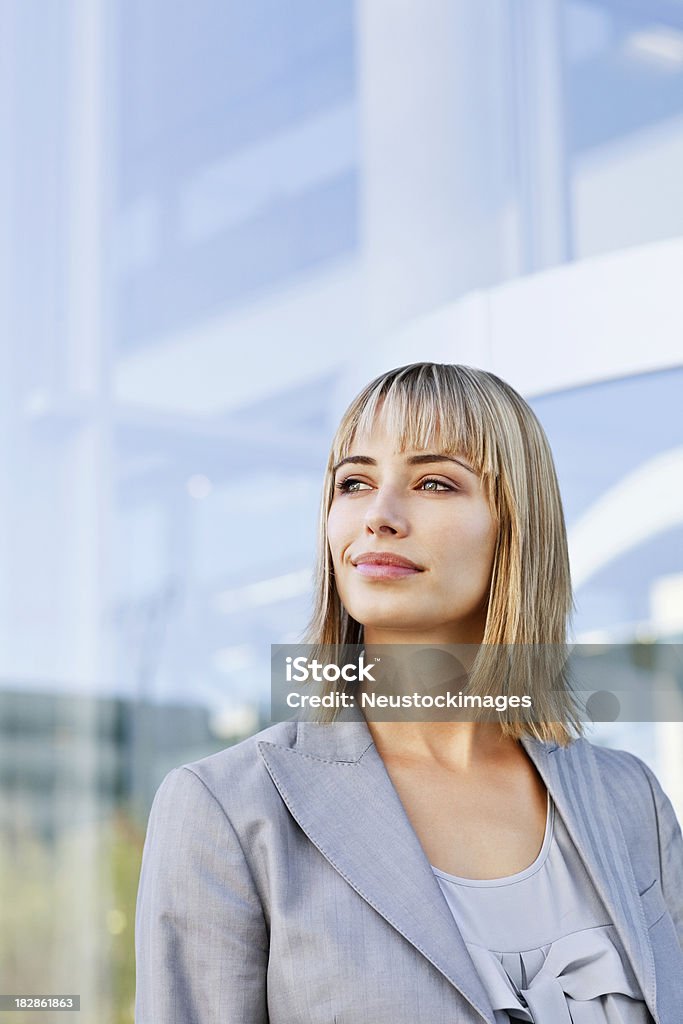 Businesswoman Smirking to the Side "Attractive, blond businesswoman gives a slight smile while looking into the distance. Vertical shot." 30-39 Years Stock Photo