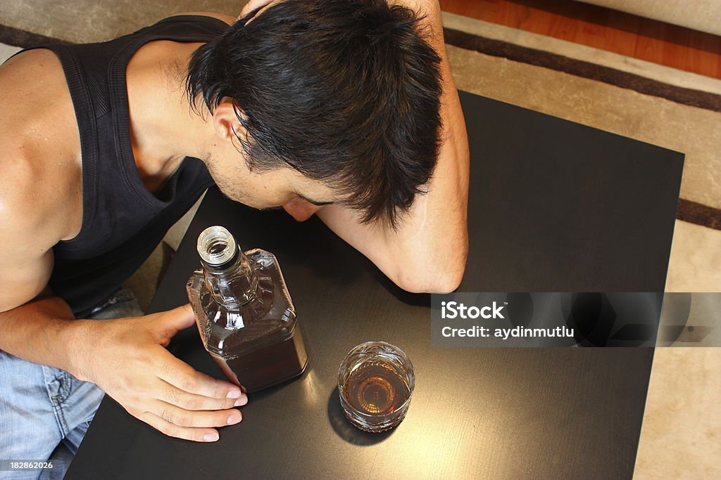 Alcoholism Young man drinking and feeling despair. Alcohol - Drink Stock Photo