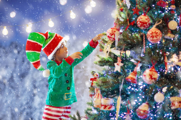 Child decorating Christmas tree. Kid on Xmas eve.