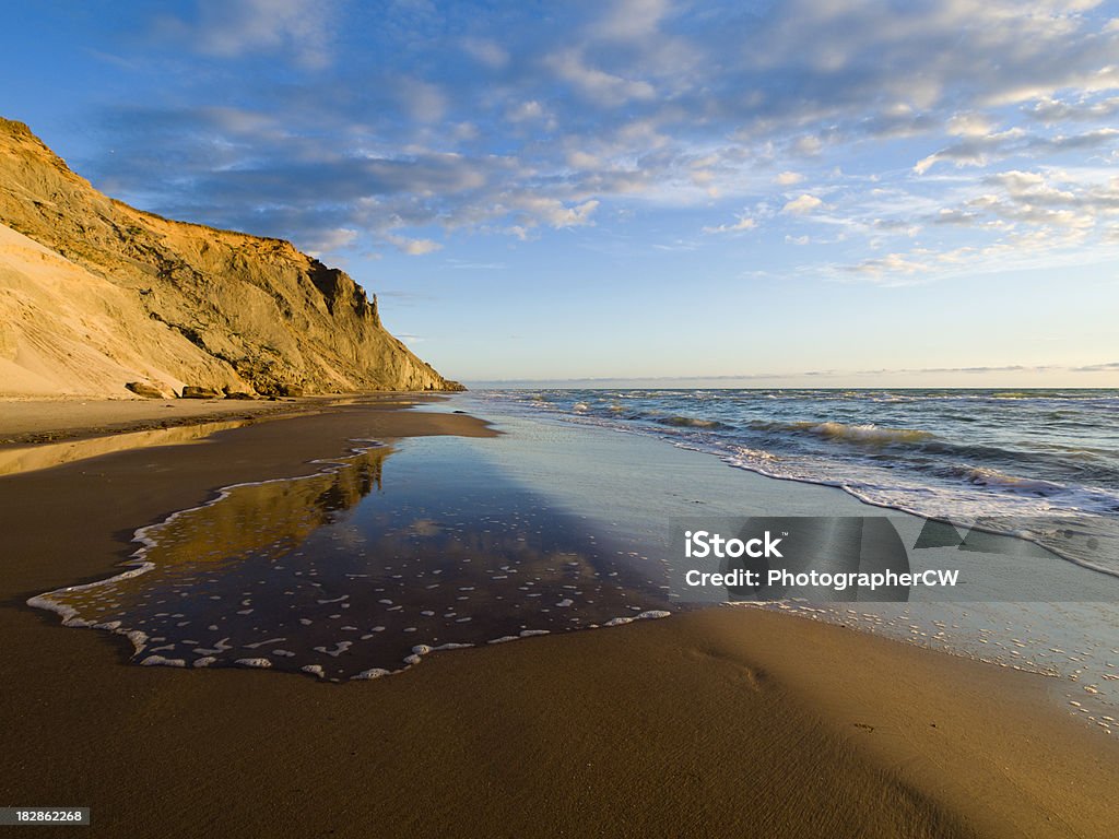 Cliff at the Danish west coast "Beach a mile shouth of Loenstrup, Denmark with the cliff reflected in a wave." Beach Stock Photo