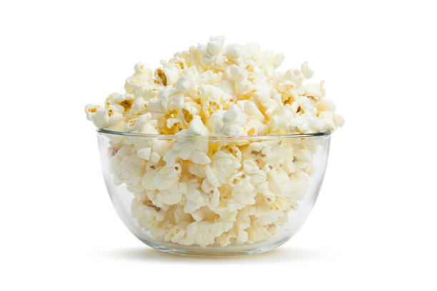 Close-up of clear bowl with freshly popped corn "A glass bowl filled to the brim with delicious, nutritious popcorn.Click on the banner below to see more photos like this." Popcorn stock pictures, royalty-free photos & images