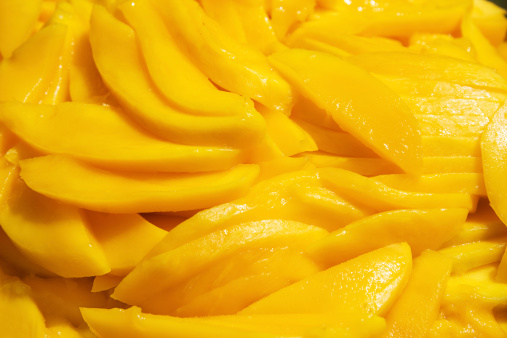 Fresh Mango slices as a background.