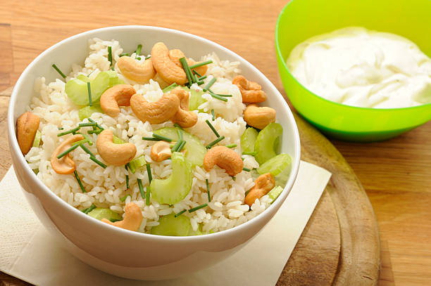 Bowl with Rice salad, celery, cashew, chive. Sause with mayonnaise, yogurt, pepper and vinegar.