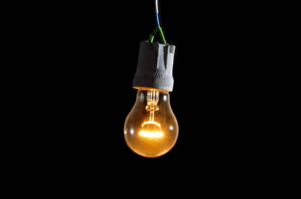 istock Glowing vintage light bulb close up on black background 1828633515