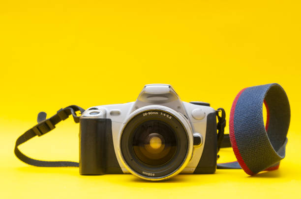 istock Old-fashioned film camera close up on a yellow background 1828633547