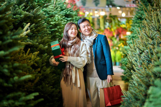 istock Asia Couple Choosing Christmas Pine Tree 1828638791