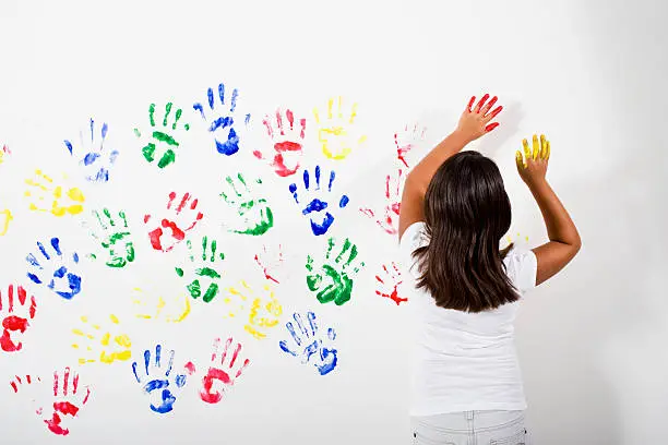 Photo of Young Hispanic Asian girl playing with finger paints