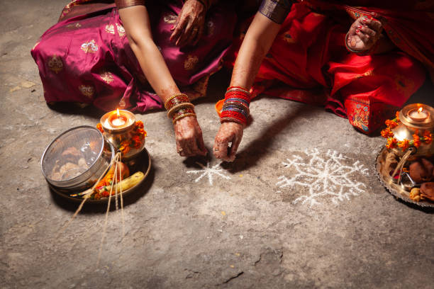 istock Two Indian women are making an Auspicious Hindu design pattern (rangoli). 1828640427