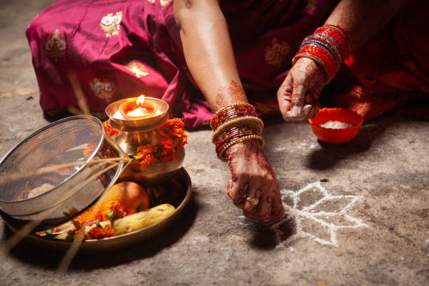 istock Two Indian women are making an Auspicious Hindu design pattern (rangoli). 1828640444