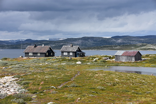 Deux maisons et un hangar dans la montagne, proches d’un lac, en Norvège